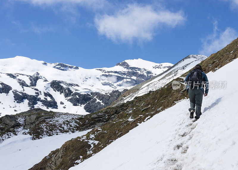 沿着积雪覆盖的山路徒步旅行的女人- xxxl